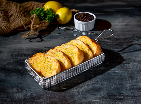 Cheese garlic bread in a deep fryer dish top view on dark background a morning meal