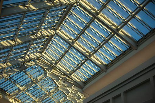Glass roof in shopping mall. Details of interior in building. Light through glass. Dome in building. Modern architecture.