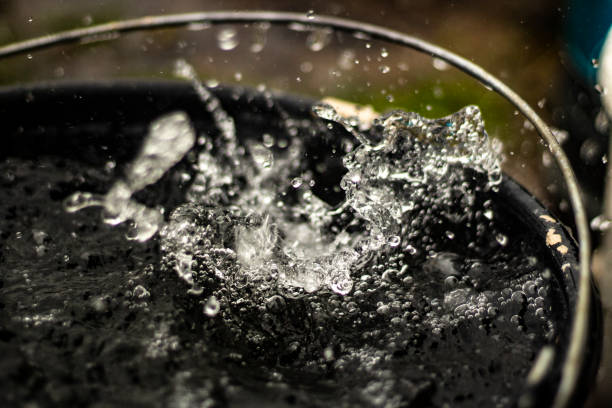 istock Rain is dripping into bucket. Water splashes in bucket. 1403261478