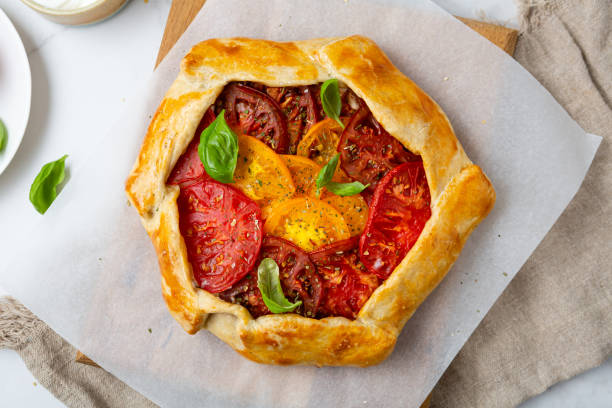 istock Food concept tomatoes heirloom tart pie with basil 1403261983