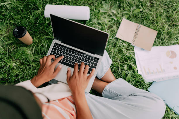 istock Male hands typing on laptop with a blank screen in the park 1403262785