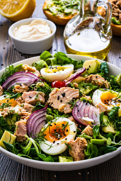 istock Tuna, boiled eggs, avocado and vegetable salad  on wooden background 1403263965