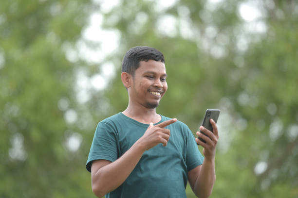 istock Young man using the phone in the park 1403264041