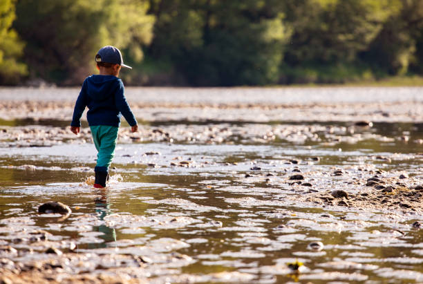 istock Little kid walking by river bank 1403266791