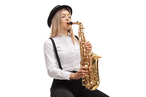 Young blond female playing a saxophone isolated on white background