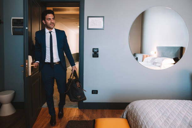 Elegant businessman opening hotel room door stock photo