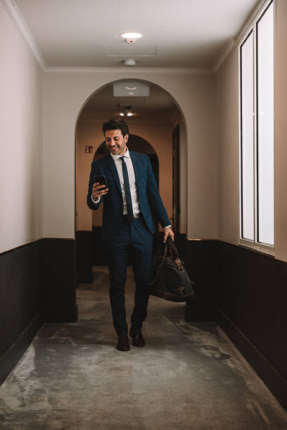 istock Businessman texting on mobile and walking to his hotel room 1403268257