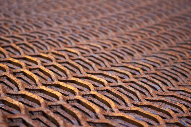Perforated rusty metal sheet stamping plates texture closeup angled view. Made through metal stamping sheet metal manufacturing lightweight bearing elements, structural combine strength functionality
