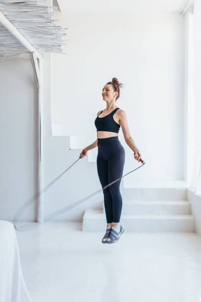 istock Fit woman with jump rope at home doing skipping workout. 1403271912