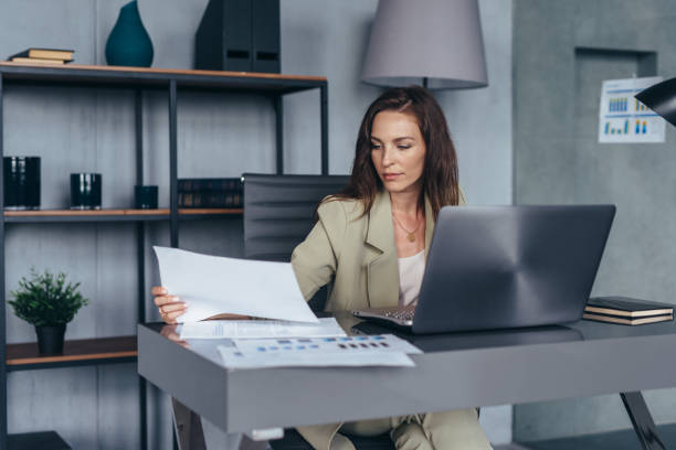 istock Woman works with documents while sitting at her desk 1403272724
