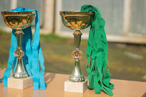 Gold Cups. Sports awards at competition. Details of football match. Products made of gold-plated steel. Symbol of victory.