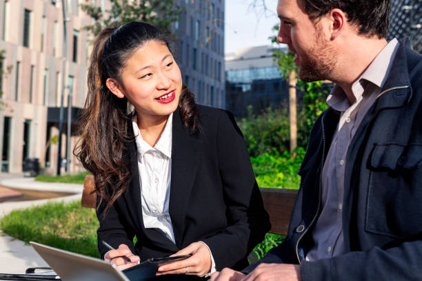 istock woman with her business partner working in a park 1403276856