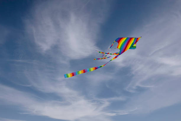 istock Colorful blue sky with white fluffy clouds and a flying colored kite 1403280415