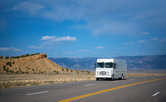 White delivery van driving on empty road in Utah
