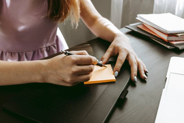istock Closeup of young businesswoman working at modern office making notes 1403280907