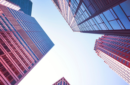 Looking up at Manhattan skyscrapers, color toning applied, New York City, USA.