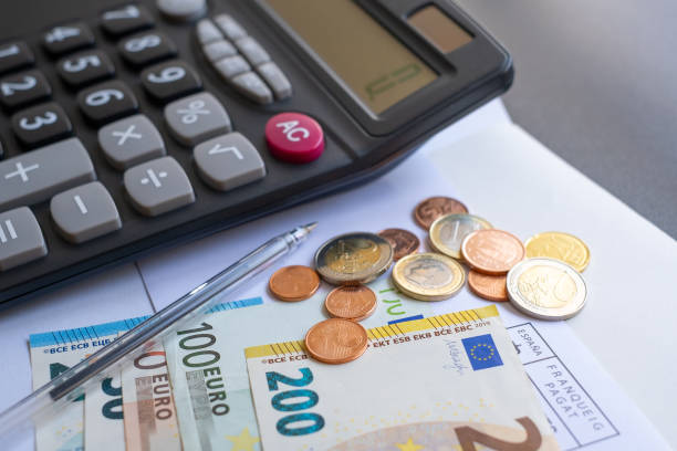 калькулятор, деньги, ручка и конверт на столе. подсчет денег. - euro paper currency стоковые фото и изображения