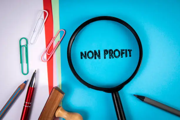 Photo of Non Profit. Magnifying glass, stationery on the office desk