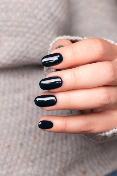 istock Female hand with black nails 1403290744