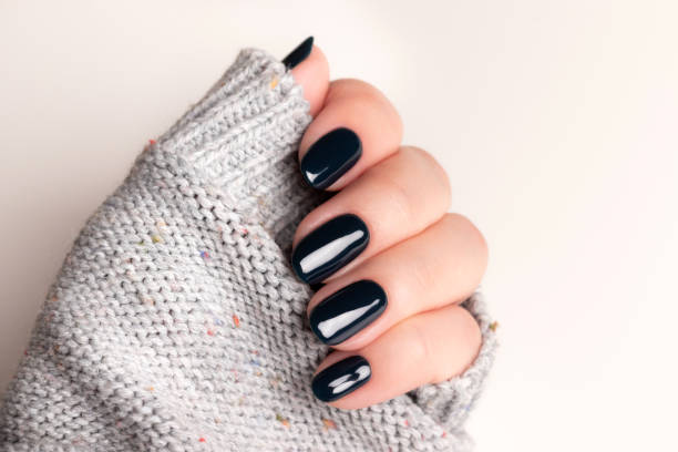 istock Female hand with black nails 1403290784