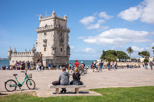 Lisbon, Portugal - May 24, 2022: Belem Tower (Torre de Belem) on a sunny day with tourists. UNESCO World Heritage Site from the early 16th century.