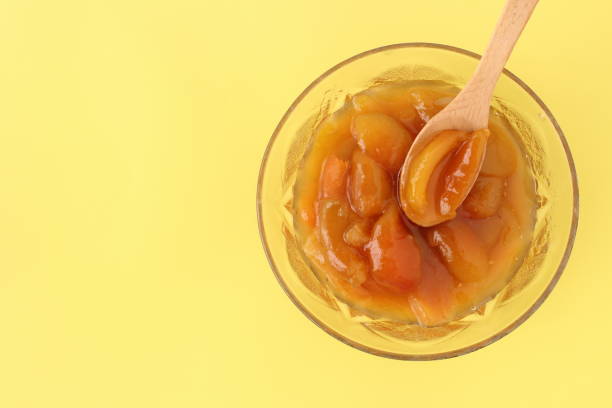 top view on one of bowl full of apricot jam with space for text isolated on yellow background. - altin stok fotoğraflar ve resimler