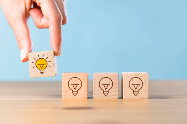 istock Woman hand picked wooden cube block with light bulb icon 1403293577