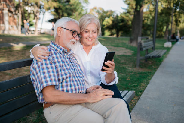 istock Elderly married couple sitting on a park bench 1403296527