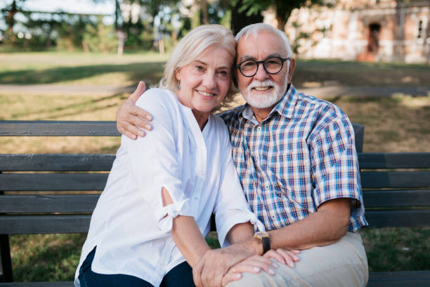 istock Senior married couple sitting on a park bench 1403296547