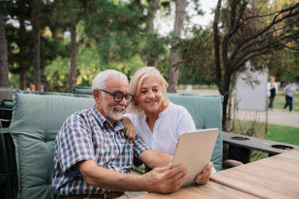 Happy senior couple facetime with family using a digital tablet computer stock photo