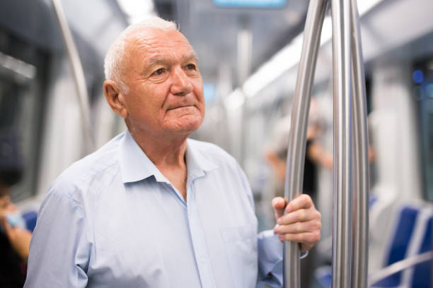 istock Old man standing in subway car 1403300458