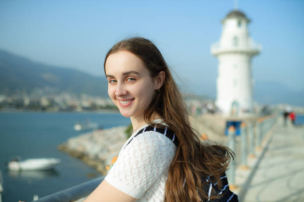 istock Young traveller enjoying a walk on a harbor with lighthouse 1403300473