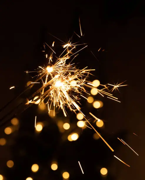 Photo of Burning several sparklers on bokeh background, abstract blur background.Holiday concept.Postcard.