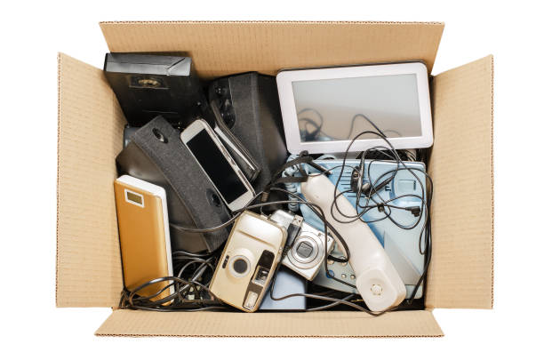 Old electronic devices in a cardboard box. The concept of recycling and disposal of electronic waste. Isolated on white Old electronic devices in a cardboard box. The concept of recycling and disposal of electronic waste. Isolated on white. electrical equipment stock pictures, royalty-free photos & images