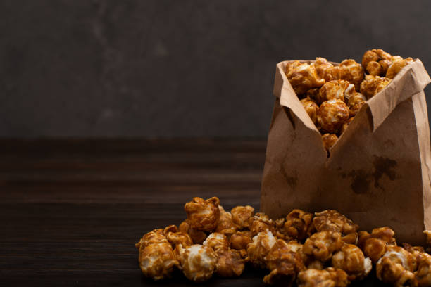 istock Caramelized popcorn in paper bag on wooden kitchen table 1403301990