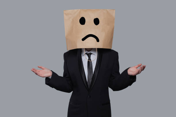 istock Businessman masked stress and doubt on gray banner background 1403303356
