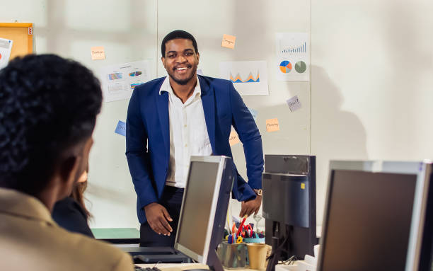 istock Handsome smart successful African black businessman making presentation about project, marketing plan to diverse coworkers in meeting room at indoor modern office. Leadership and Multiracial Concept. 1403303806