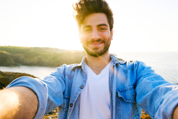 istock Happy man taking selfie using mobile phone at sunset on outdoor 1403305066