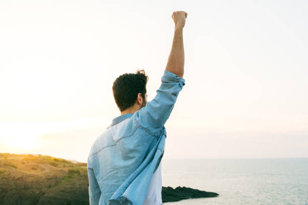 Arms raised happy success winning man looking away