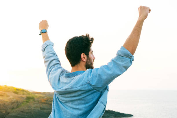 istock Arms raised happy success winning man looking away 1403306371