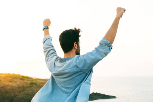 istock Arms raised happy success winning man looking away 1403306372