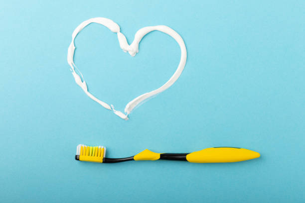istock Heart symbol made from toothpaste. Heart made of toothpaste and a toothbrush on a blue background. Refreshing and whitening toothpaste. Copy space for text. Flat lay 1403307958