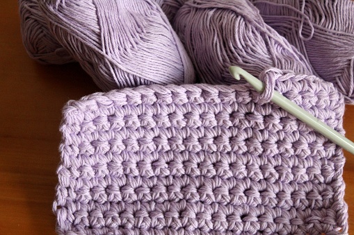 Crochet work: trivet or potholder made of lavender cotton yarn. Crochet hook. Solid stitches. A pretty souvenir or gift.