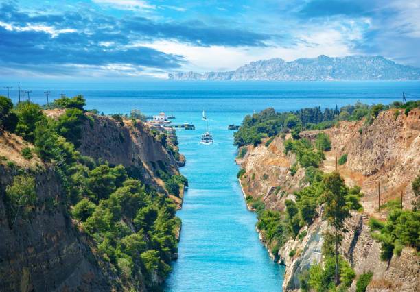 scenic landscape of the corinth canal in a bright sunny day against a blue sky with dramatic clouds - gulf of corinth imagens e fotografias de stock