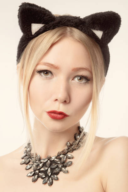 fun pretty girl with cat ears on white background looking at camera