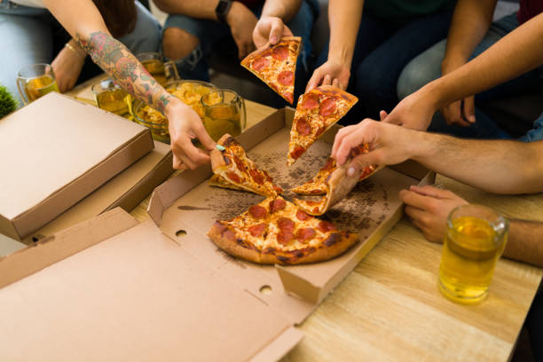 istock Friends eating a pepperoni pizza while hanging out 1403313170
