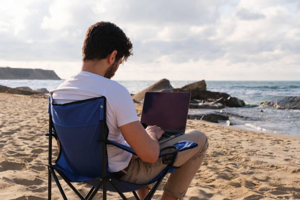 istock Young man working from away at coastline 1403318802