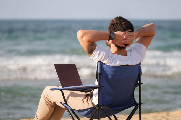 istock Young man working from away at coastline 1403318876