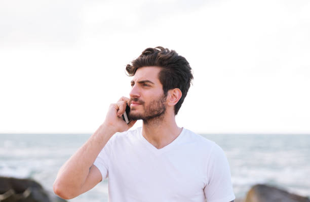 istock Happy handsome man using mobile phone at beach on outdoor 1403319264