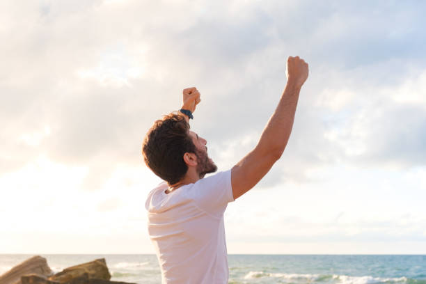 istock Arms raised happy success winning man looking away 1403320215